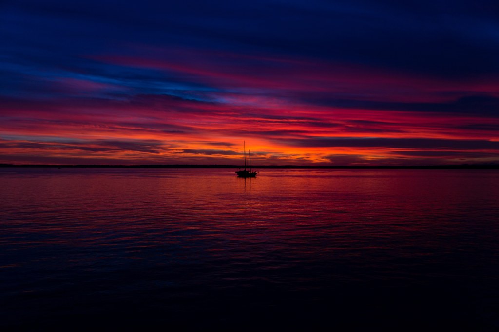 Un horizonte donde el mar y el cielo se funden bajo un atardecer de tonos rosados y púrpuras.